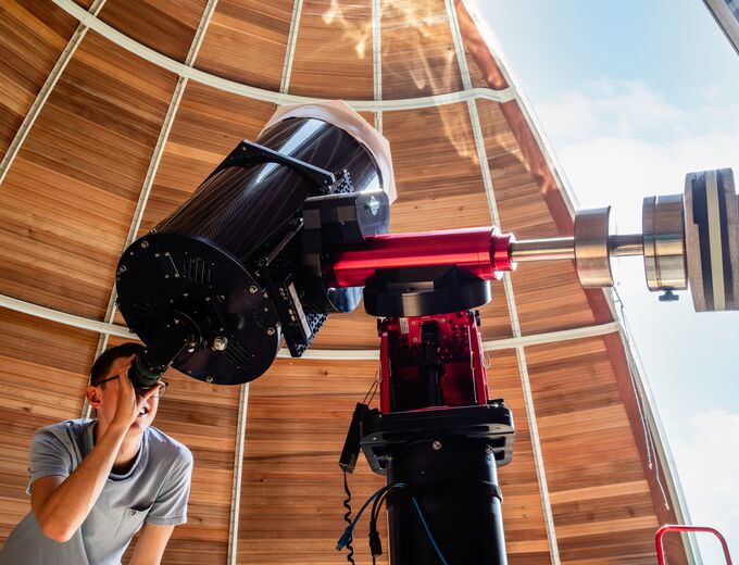 Student using telescope at observatory